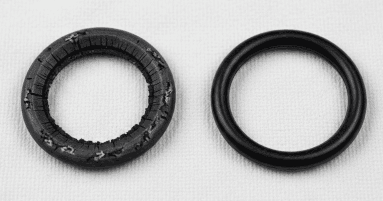 Degraded mechanical seal O-ring with visible radial cracking and extrusion marks compared to a new O-ring of the same compound